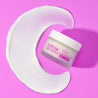 cream closed jar on moon shaped cream swatch on a pink table