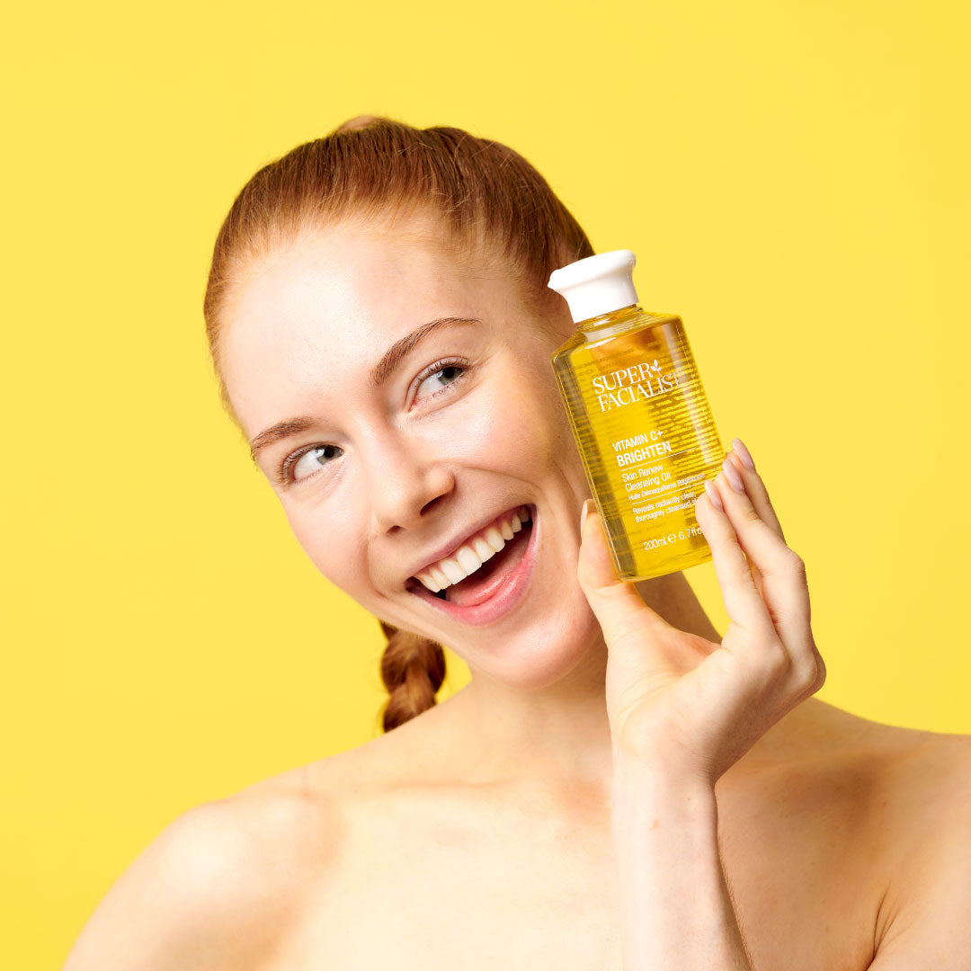 Model holding Superfacialist Vitamin C Cleansing Oil
