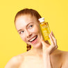 Model holding Superfacialist Vitamin C Cleansing Oil