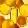 Cleansing Oil bottle between slices of juicy oranges 