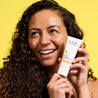 Model holding Vitamin C+ Daily Moisturiser