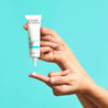 hand squeezing cream onto finger with the other hand