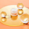 Vitamin C Night Cream jar opened between glass balls