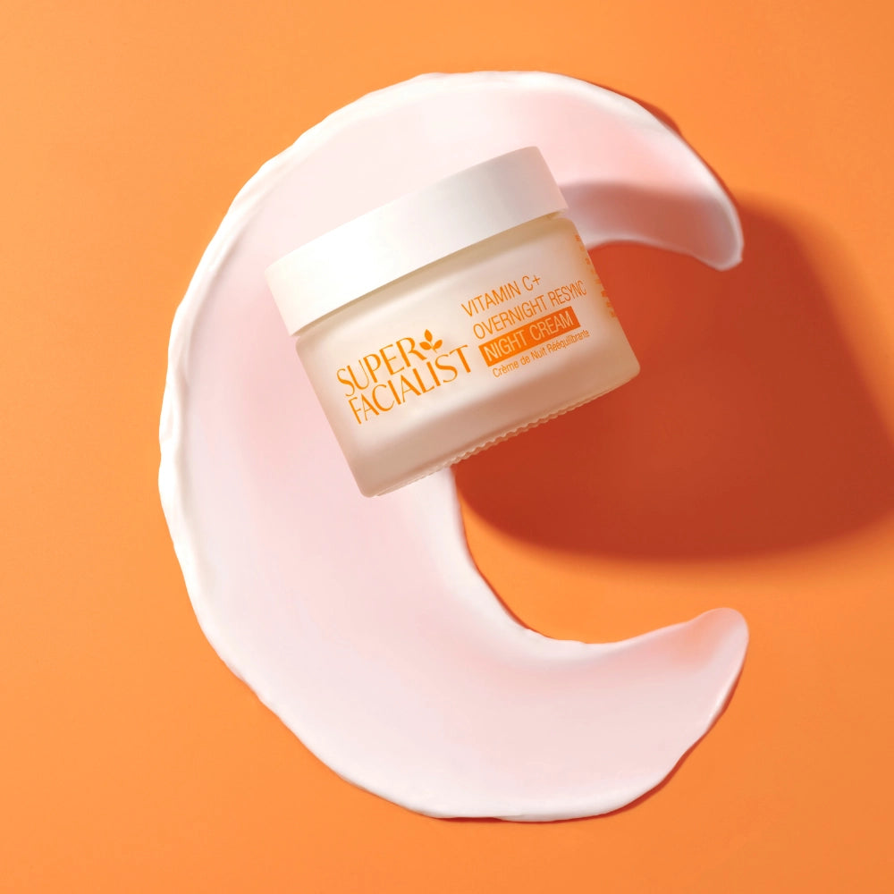 Vitamin C SleepSmart Night Cream on a moon-shaped cream swatch and orange background