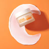 Vitamin C SleepSmart Night Cream on a moon-shaped cream swatch and orange background
