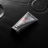 tube on water with black ground and two drops  that ripple around the tube