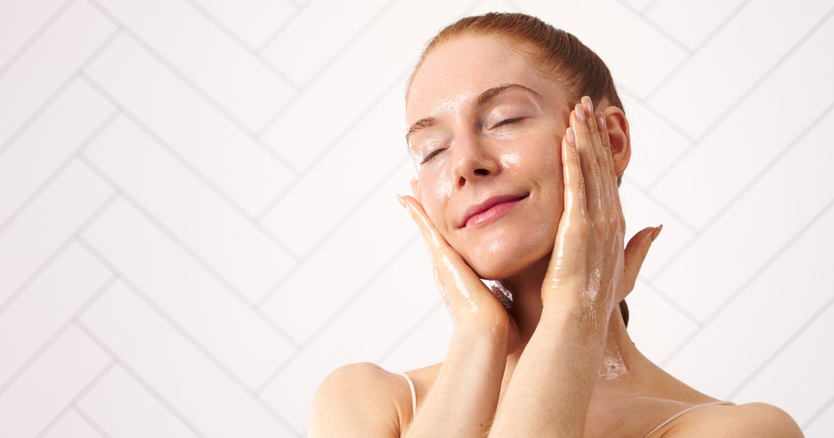 Woman double cleansing with cleansing oil against white background