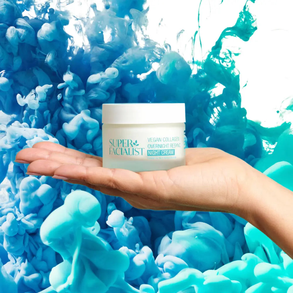 hand holding vegan collagen night cream in hand against a blue turquoise changing background