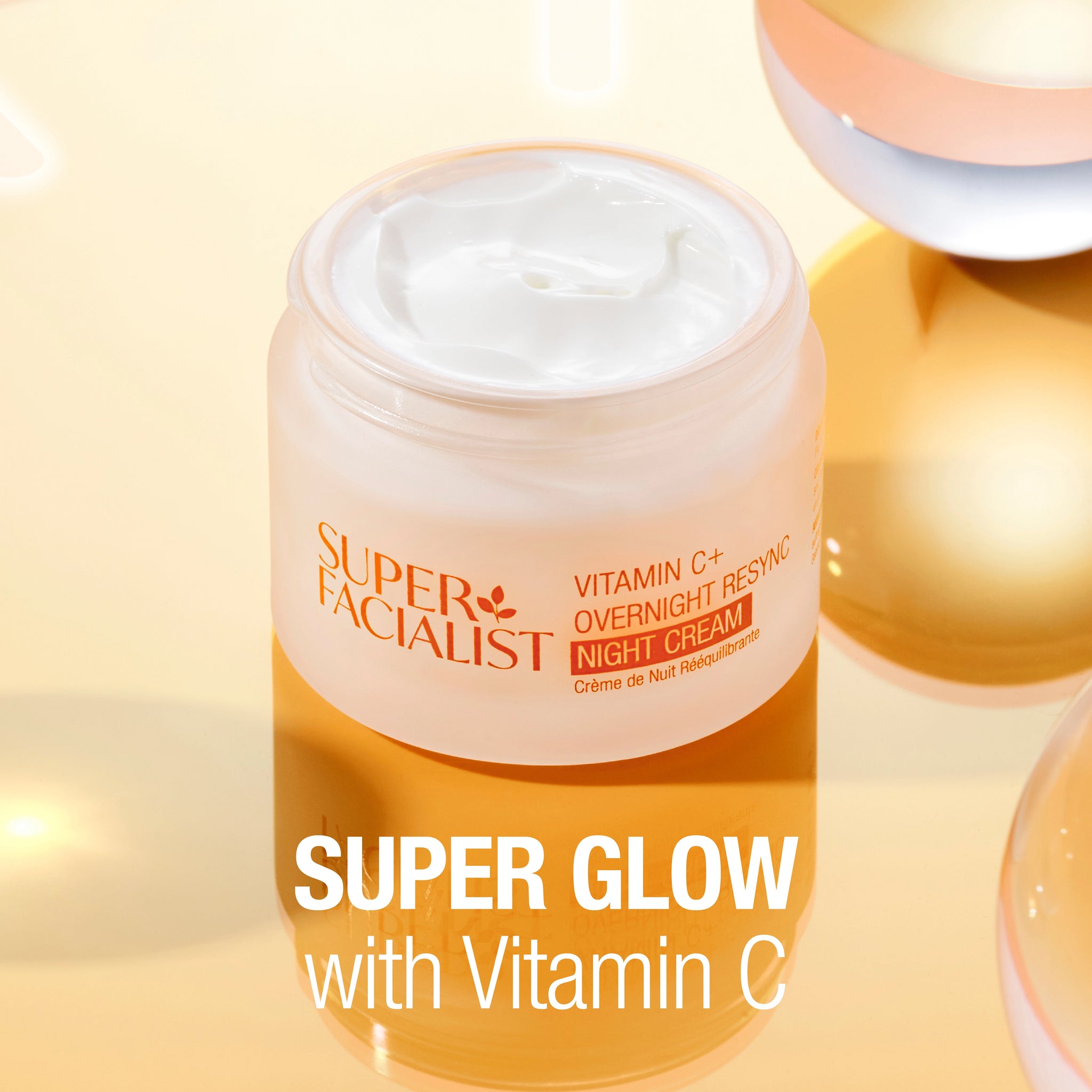 Open jar with cream inside against a glass mirror background. "SUPER GLOW with Vitamin C" text overlay.