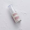 Serum bottle on white table with bubbles around it