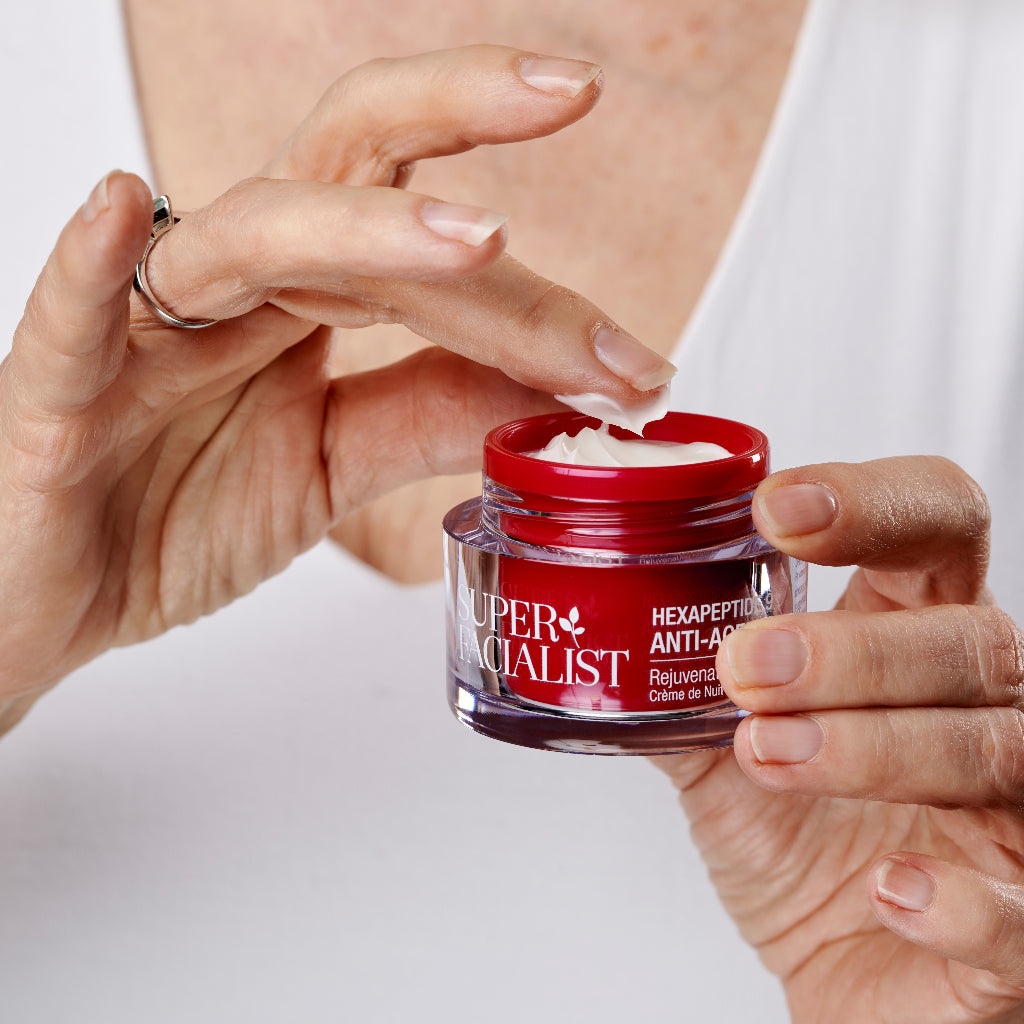 Hand dipping a finger into night cream