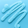Close up shot of the cleanser gel poured in squiggles on blue table