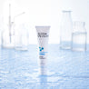 Firming facial serum bottle in a lab with water droplets on the tube