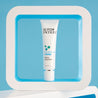 Serum tube inside a white square prop in front of a light blue background