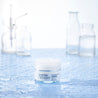Hyaluronic acid night cream jar in a lab with water droplets around the jar