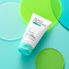 Clear Skin Exfoliator tube on top of green and blue glass circles