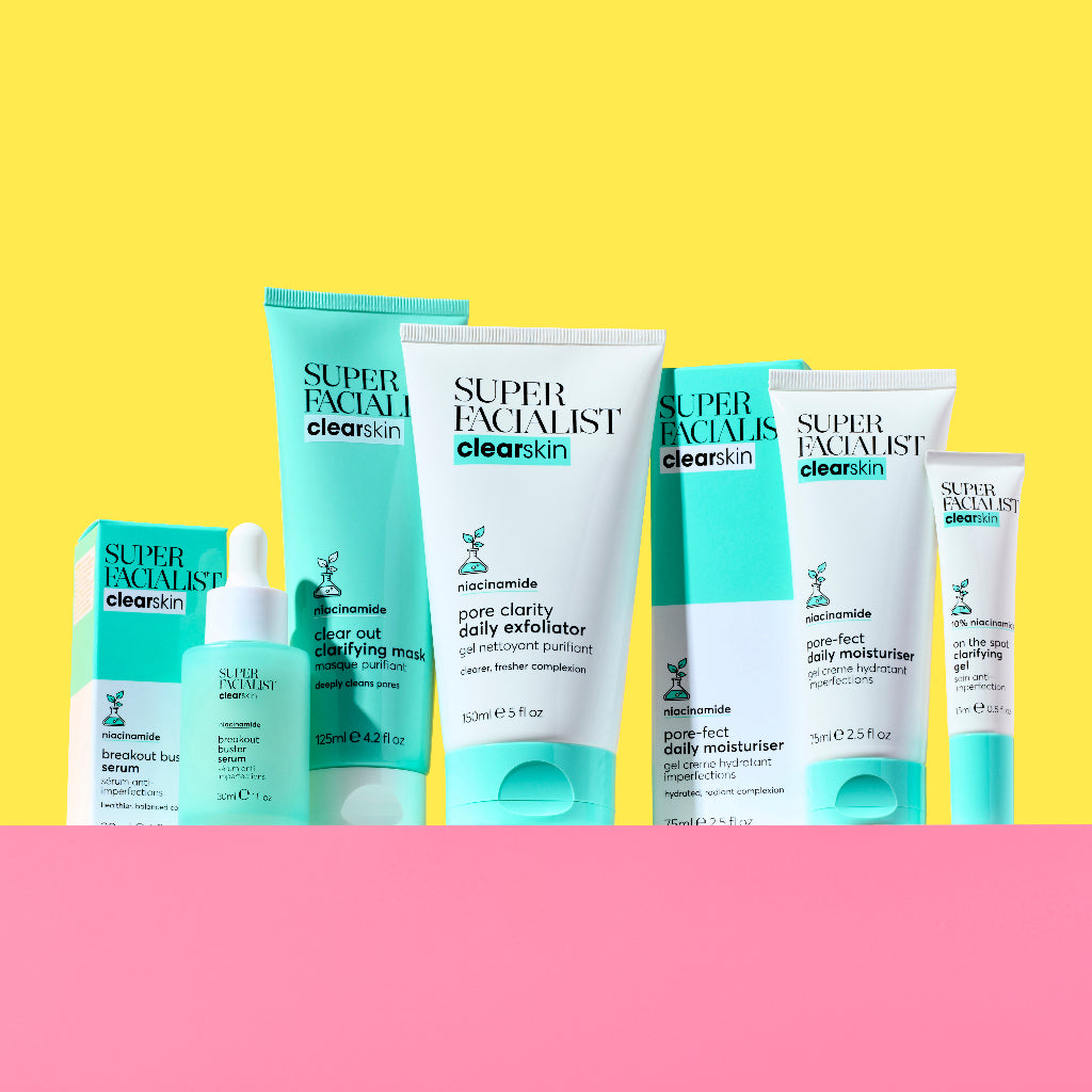 Full Super Facialist Clear Skin range lined up on a pink table and yellow background