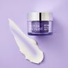 Night cream jar next to creamy swatch on purple background