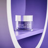 Retinol night cream inside a circular prop on purple background