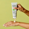 Hand squeezing out clay mask onto the back of another hand