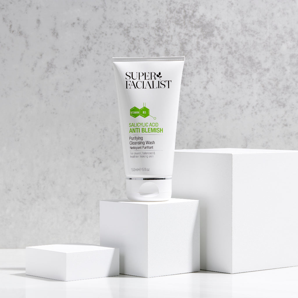 Salicylic acid cleansing wash tube on white cubes against an off white background