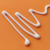 Vitamin C Serum texture shot of wiggly white serum texture on orange coloured table